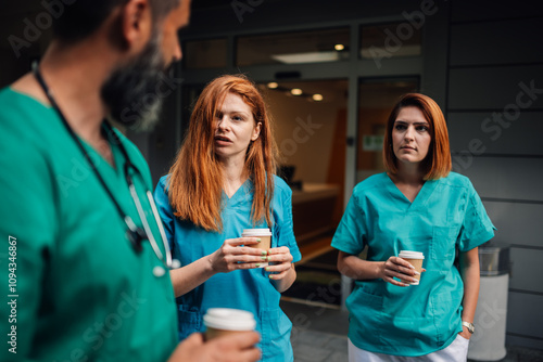 Healthcare team conversing during a break, standing outside a clinic. photo