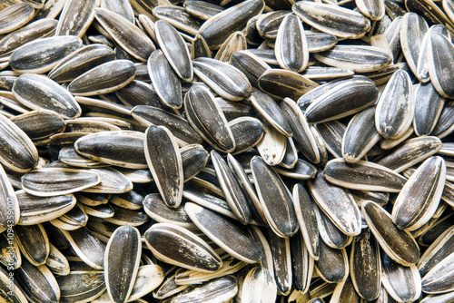Close-up of sunflower seeds with black and white skin.
