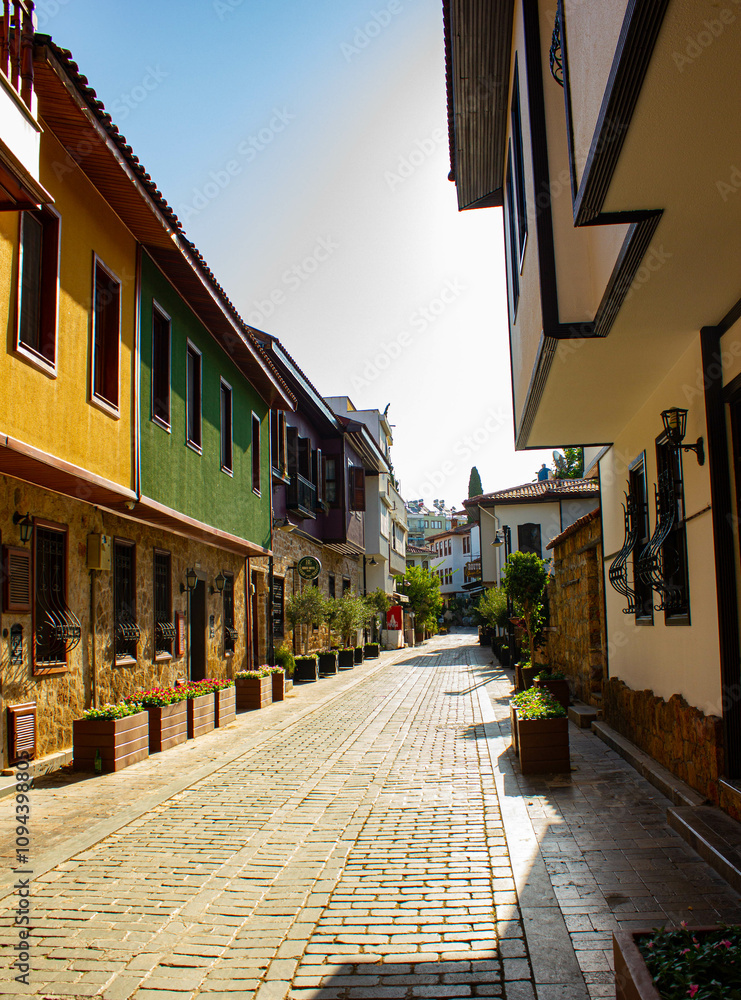 Fototapeta premium Narrow bright street with stores and cafes in the old town of city Antalya in Turkey