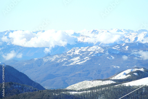 Winter in northern Montenegro: landscape with snow-capped mountains and low clouds. View from the upper station of the ski lift at the Kolasin 1600 ski resort (Biogradska Gora National Park) photo