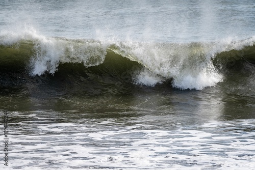 Dynamic ocean wave crashing with sunlight reflections.