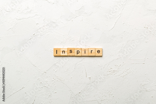 Inspire word written on wood block. Inspire text on cement table for your desing, concept photo