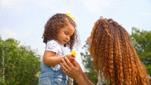 Fotografie Young Daughter Giving Mother Flower She Has Picked Outdoors In Garden