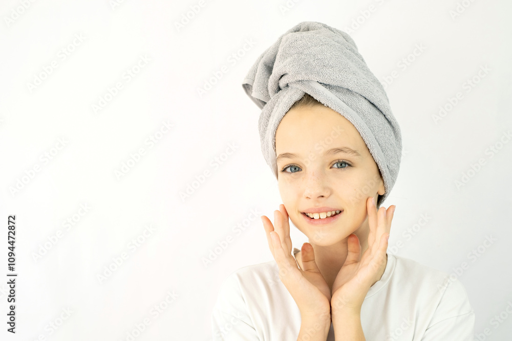 Beautiful teenage girl with towel on her head in white t-shirt on white background, smearing her face with cream. Teen Skin Care, Moisturizing Beautiful teenage girl with towel on her head in white t-shirt on white background, smearing her face with cream. Teen Skin Care, Moisturizing