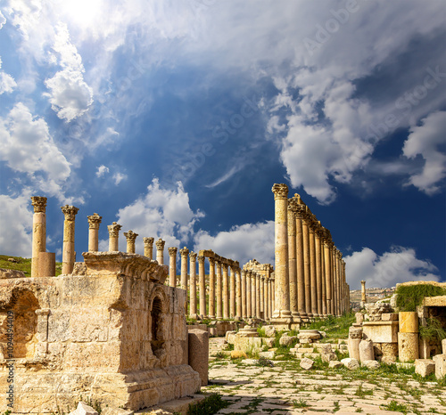 Roman ruins (against the background of a beautiful sky with clouds) in the Jordanian city of Jerash (Gerasa of Antiquity), capital and largest city of Jerash Governorate, Jordan #1094494409