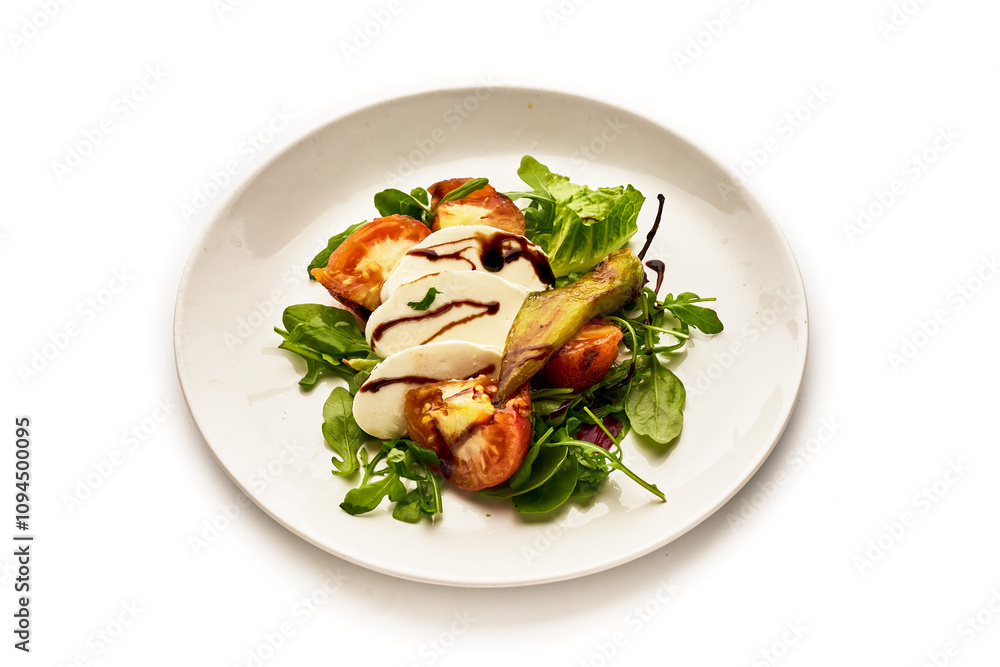 A white plate with a salad of tomatoes, cucumbers, and basil A white plate with a salad of tomatoes, cucumbers, and basil