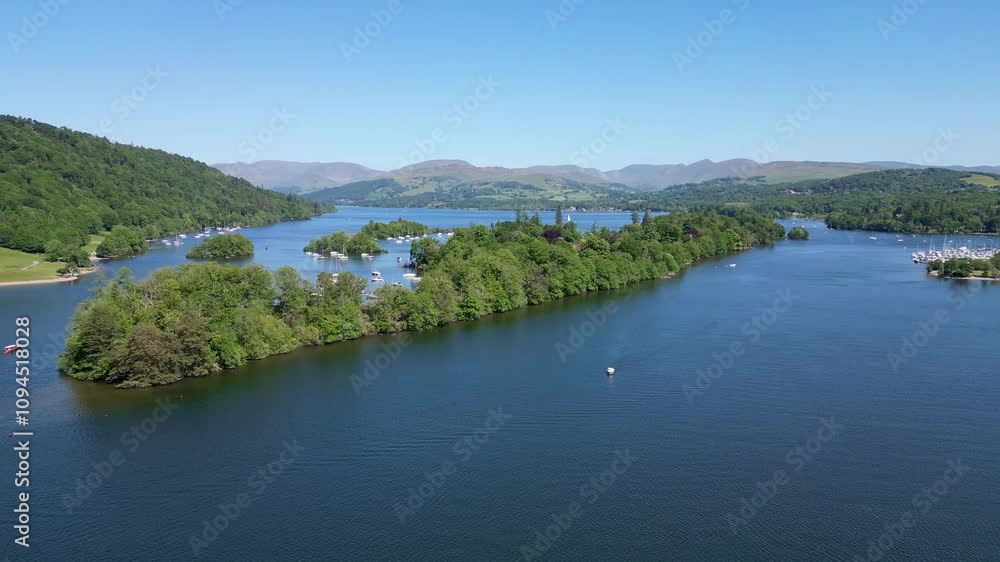 Drone orbit of Belle Isle on Lake Windermere, The Lake District on a summer day, with a ferry, boats and Bowness in the background Drone orbit of Belle Isle on Lake Windermere, The Lake District on a summer day, with a ferry, boats and Bowness in the background