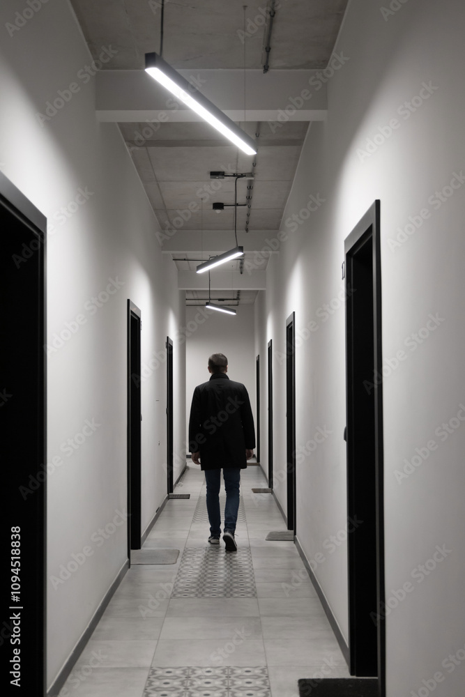 man in black jacket in modern corridor man in black jacket in modern corridor