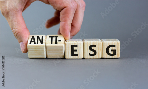 Anti-ESG environment social governance symbol. Concept word Anti-ESG on wooden cubes. Businessman hand. Beautiful grey background. Business Anti-ESG environment social governance concept. Copy space.
