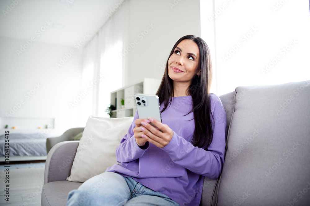 Charming woman enjoying a relaxing weekend at home in a stylish pullover, smiling during a peaceful moment in the living room Charming woman enjoying a relaxing weekend at home in a stylish pullover, smiling during a peaceful moment in the living room