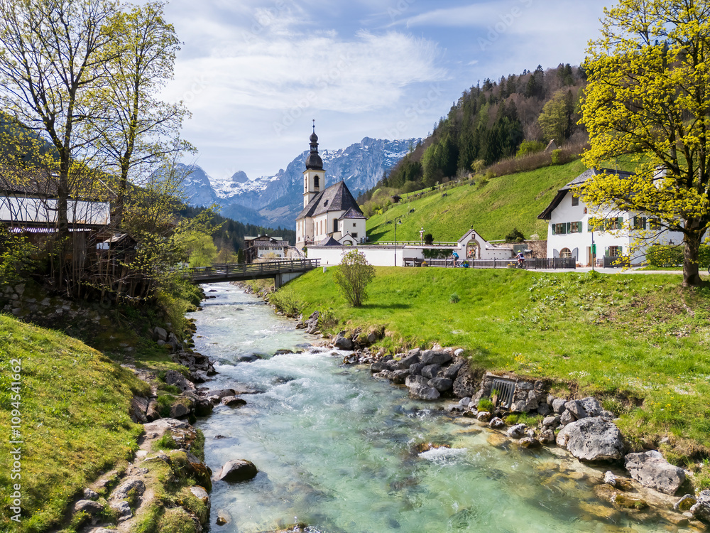 View to a famous church in Berchtesgaden bavarian region with a wild river and a mountain background View to a famous church in Berchtesgaden bavarian region with a wild river and a mountain background