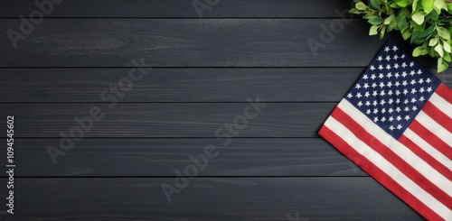 American flag resting on dark wooden surface with greenery