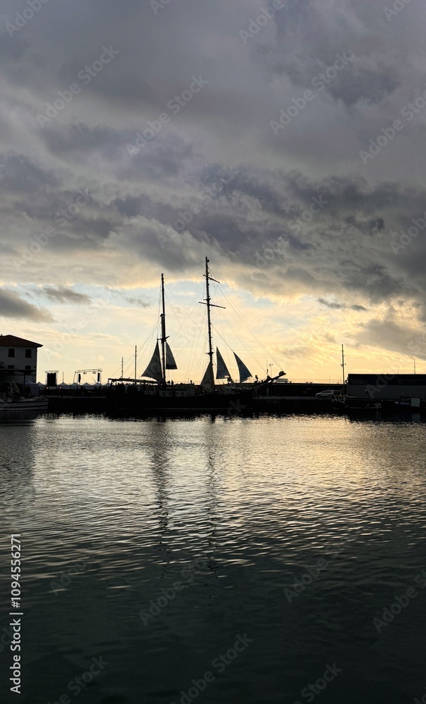 Silhouette of a pirate ship docked in the harbor, with storm clouds looming in the background, creating an atmosphere of mystery and suspense. Silhouette of a pirate ship docked in the harbor, with storm clouds looming in the background, creating an atmosphere of mystery and suspense.