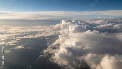 Breathtaking view of fluffy white clouds captured from an airplane window, showcasing a serene expanse of the sky bathed in soft sunlight, offering a tranquil glimpse into the beauty of