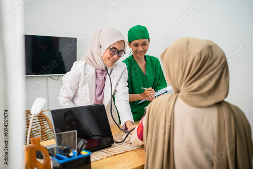 Two dedicated doctors carefully consult with a patient in a welcoming and warm medical environment