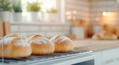 Freshly baked bread rolls cooling on a rack in a warm kitchen during the morn...
