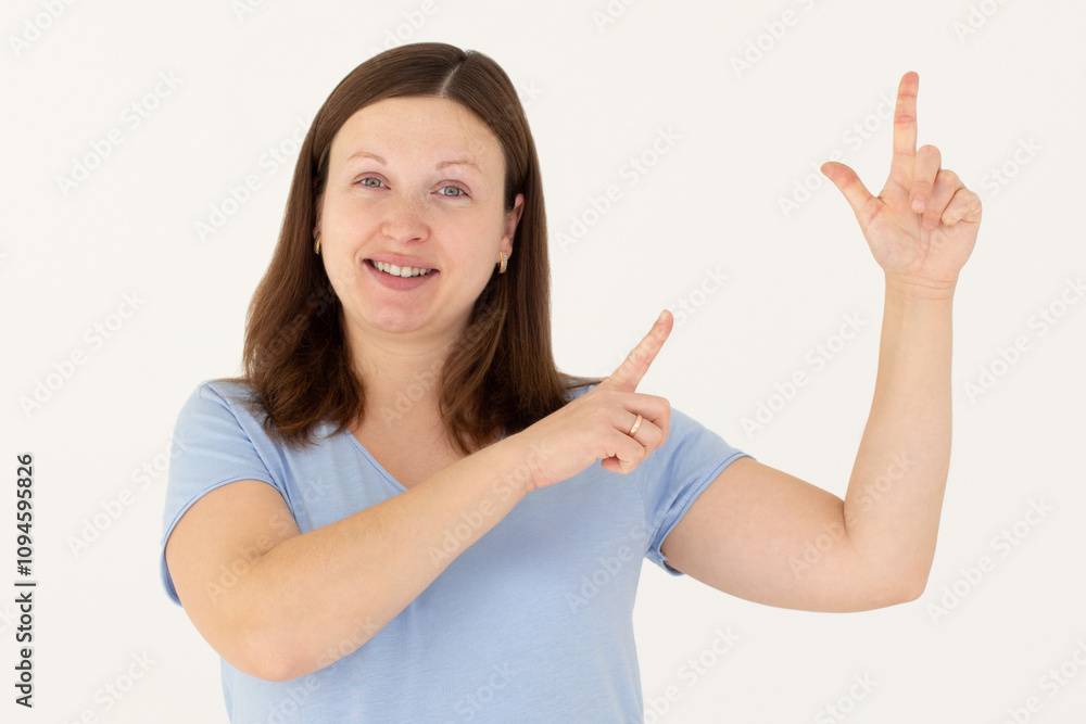 Hey look. Smiling pretty female model pointing fingers right at empty space and inviting to check it out, showing advertisement on white background. Hey look. Smiling pretty female model pointing fingers right at empty space and inviting to check it out, showing advertisement on white background.