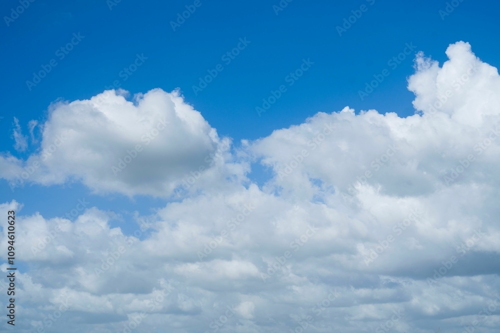 Blue sky filled with white, fluffy clouds on a sunny day Blue sky filled with white, fluffy clouds on a sunny day