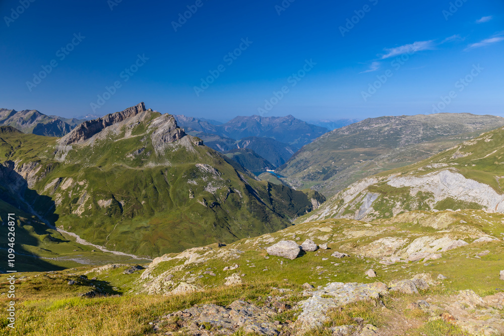 Tour du Mont Blanc beautiful landscapes in the Alps mountains on a sunny summer day. Green grass on the alpine meadow surronded by high mountain peaks of Montbalnc alpine range Tour du Mont Blanc beautiful landscapes in the Alps mountains on a sunny summer day. Green grass on the alpine meadow surronded by high mountain peaks of Montbalnc alpine range