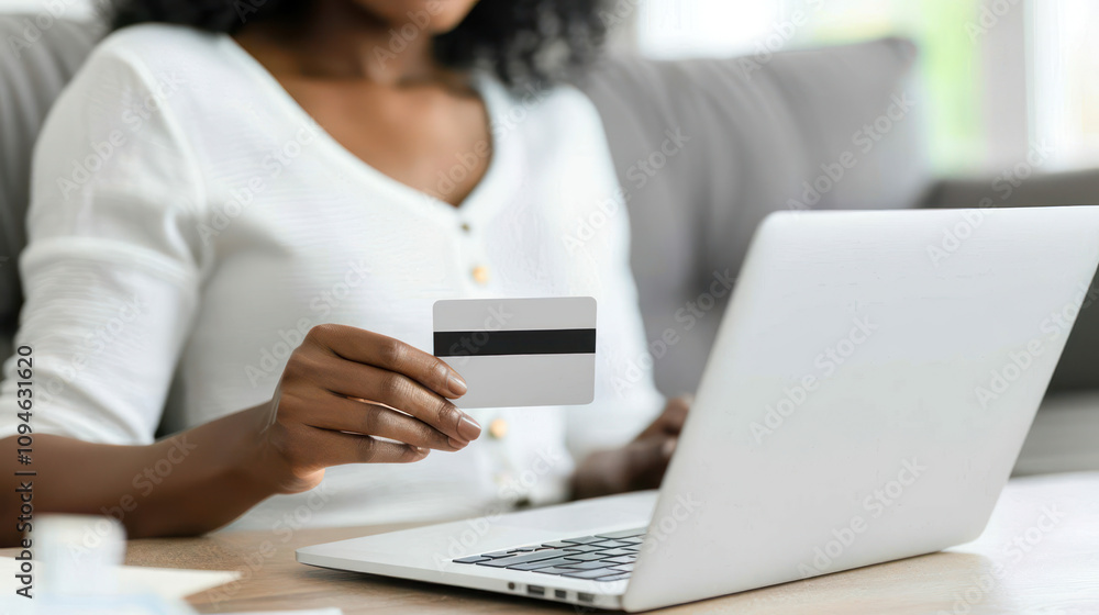 Woman Holding Credit Card While Shopping Online with Laptop in a Bright and Cozy Living Room Setting Woman Holding Credit Card While Shopping Online with Laptop in a Bright and Cozy Living Room Setting