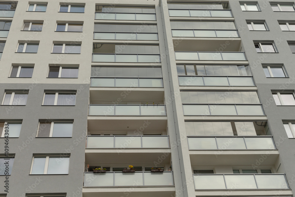 The sleek facade of a modern apartment features elegant balconies and large, inviting windows The sleek facade of a modern apartment features elegant balconies and large, inviting windows