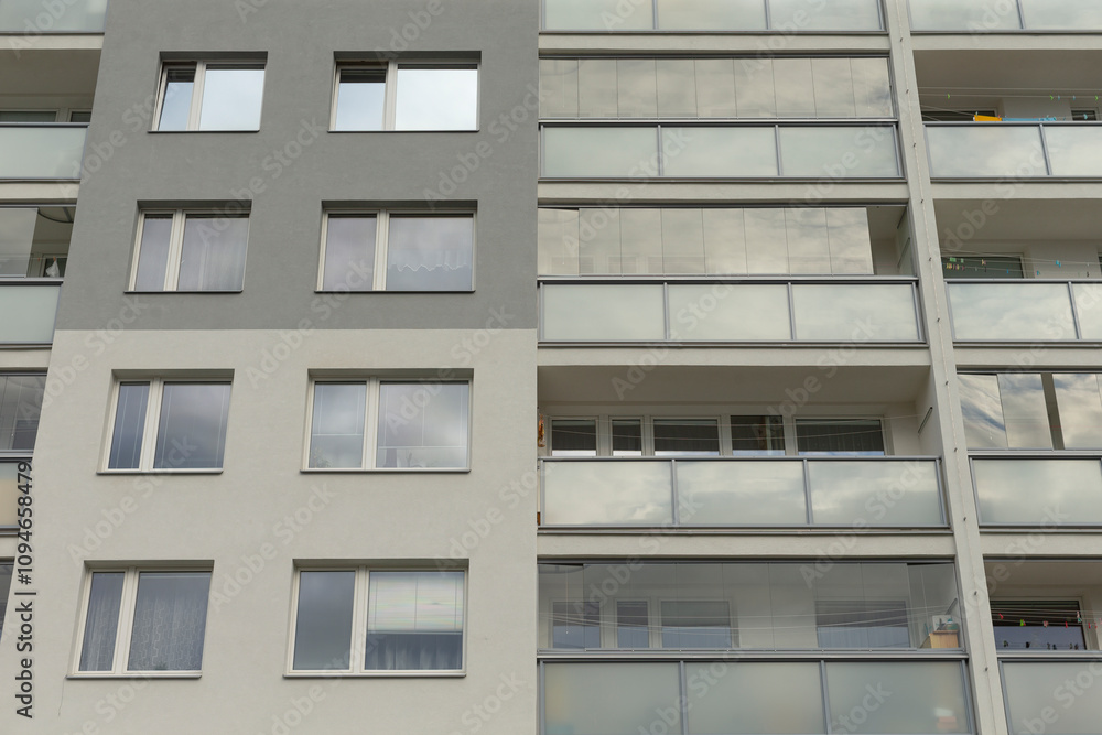 The facade of a sleek, modern apartment building beautifully showcasing numerous balconies and large windows The facade of a sleek, modern apartment building beautifully showcasing numerous balconies and large windows