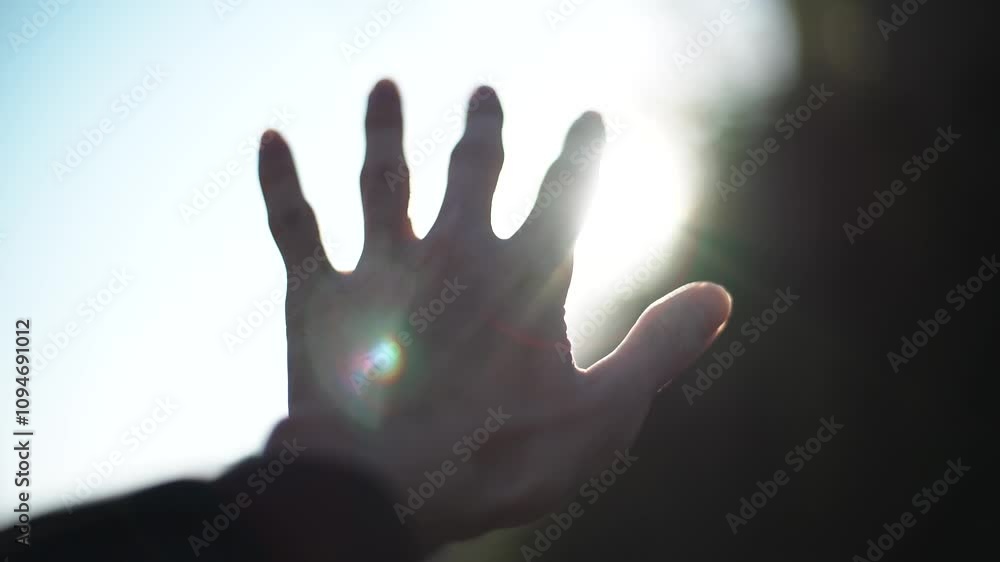 太陽に向かって手をのばす男性 太陽に向かって手をのばす男性