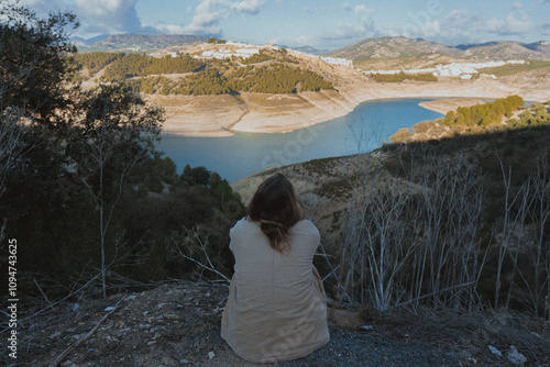 Woman in the edge of a valley, watching the landscape with the river in a afternoon day of summer in south of Spain