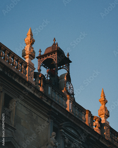 Old clock in the top of an beautiful building in Sevilla, at the golden hour