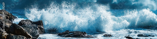 Crashing Waves: A powerful wave crashing onto a rocky shore, sending water flying through the air. photo