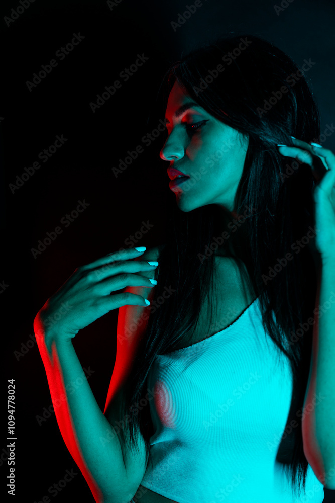© FATIR29 - High Fashion model woman in colorful bright neon blue and purple lights posing in studio. Portrait of beautiful woman with trendy glowing make-up. Art design vivid style