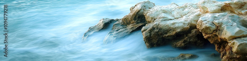 Seafoam Reflections: Soft waves lapping against a rocky shore photo