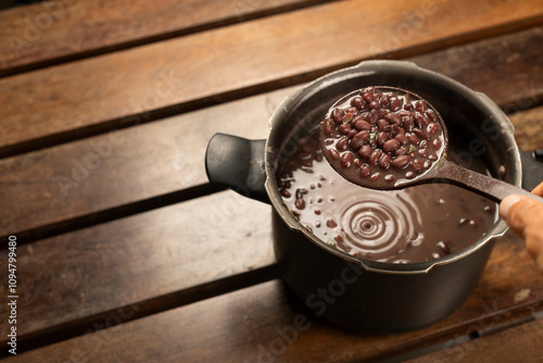 Black Beans Cooked in the pressure cooker with a bean ladle on a wooden desk photo