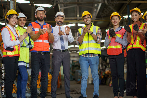 group of diversity engineer factory worker standing clapping hand celebrate job finished with businessman manager or executive boss leader team together in industry manufacturing warehouse.