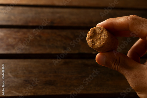 A guy's hand taking one Sweet Brazilian Peanut Called Paçoca