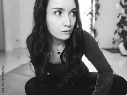 girl sitting on the floor looks disconsolately at the room photo