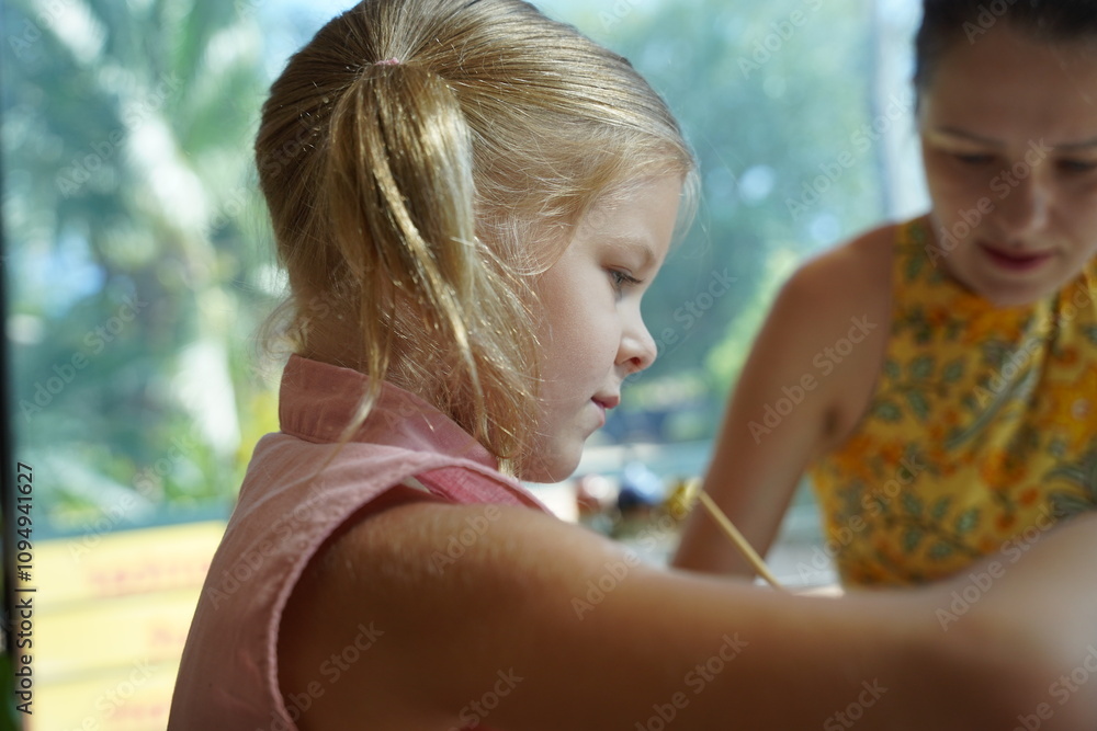 A young mother and her daughter enjoy a creative art session at home A young mother and her daughter enjoy a creative art session at home
