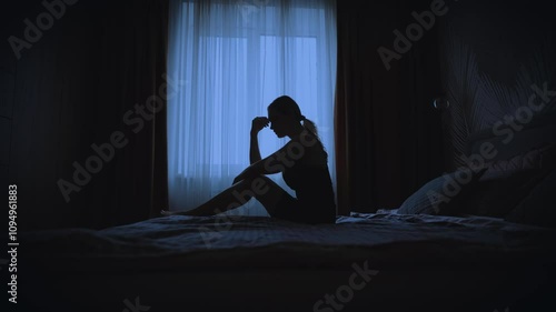 black silhouette upset unhappy woman sitting on bed dark room, mood depression sadness emotion. Sad lonely Girl feels bad after party, migraine suffers from headache. window curtains white fabric