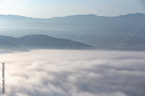 The weather is hot and humid, with a lot of water vapor creating a sea of mist in the foreground in the valley