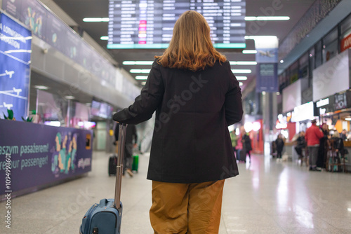 Portrait of Caucasian traveler woman hold ticket ready enjoy voyage tour passenger walk in airport terminal to boarding gate. Attractive beautiful female tourist excited to go travel abroad by photo