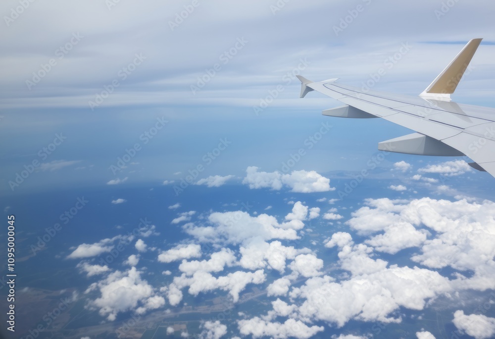 Airplane WingIn flight with clouds and landscape below Airplane WingIn flight with clouds and landscape below