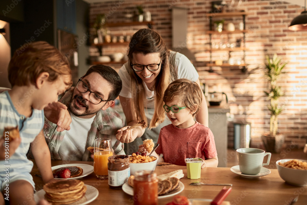 Happy family having breakfast together in cozy kitchen