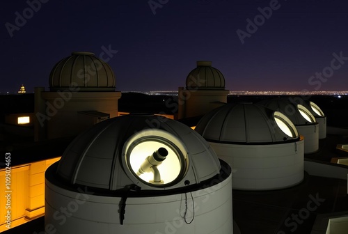 _ - Observatory rooftops with circular windows lit to reveal tel