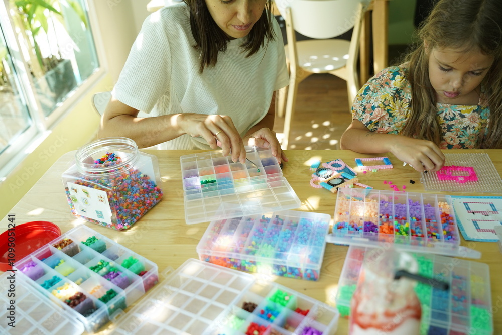 Fototapeta premium Teacher in workshop teched two girls how to assemble a thermo mosaic 