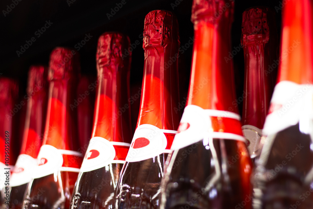 Champagne bottles with red foil in a wine cellar
