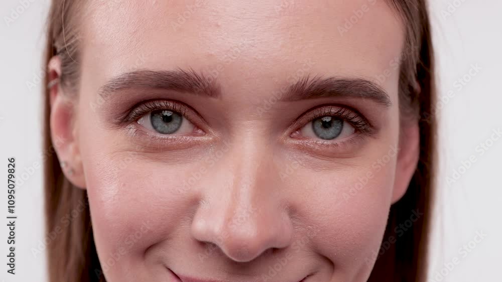 Portrait of attractive girl with healthy clean skin and beautiful make-up. Aesthetic cosmetology and makeup concept.She holds a flower near her face Portrait of attractive girl with healthy clean skin and beautiful make-up. Aesthetic cosmetology and makeup concept.She holds a flower near her face