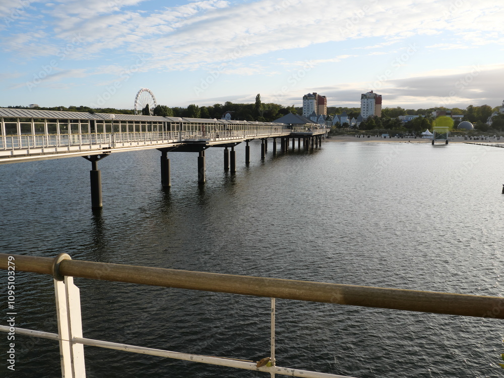 Die Seebrücke von Bansin und ein weißes Riesenrad mit Gondeln am Strand von Bansin auf Usedom Die Seebrücke von Bansin und ein weißes Riesenrad mit Gondeln am Strand von Bansin auf Usedom