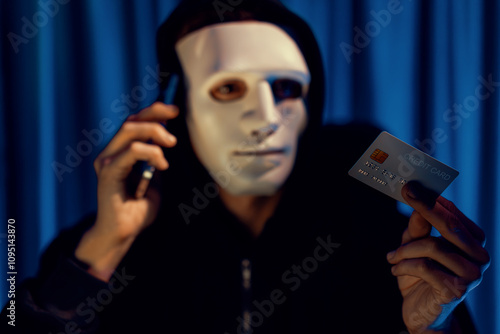 White criminal anonymous mask calling to credit card owner to threaten ransom with privacy information all database, making password encryption by programming hack trying to make insecure. Pecuniary. photo