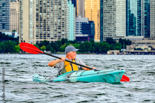 Canvas Print senior man sea kayaking on toronto inner harbour with city skyline in background room for text