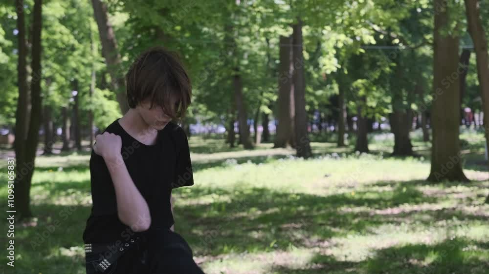 Young man in black practices breakdancing poses in a sunny park, showcasing energy and confidence amidst nature Young man in black practices breakdancing poses in a sunny park, showcasing energy and confidence amidst nature